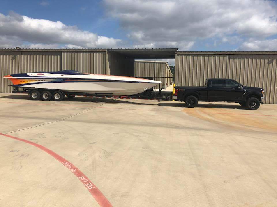 Truck pulling boat in front of storage units